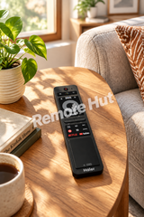 A black Haier remote control with a glossy finish, featuring a central circular navigation pad, multiple button clusters, and a small touch screen at the bottom. The brand name 'Haier' is printed in white at the bottom, and 'Netflix' and 'YouTube' logos are visible on the button area.