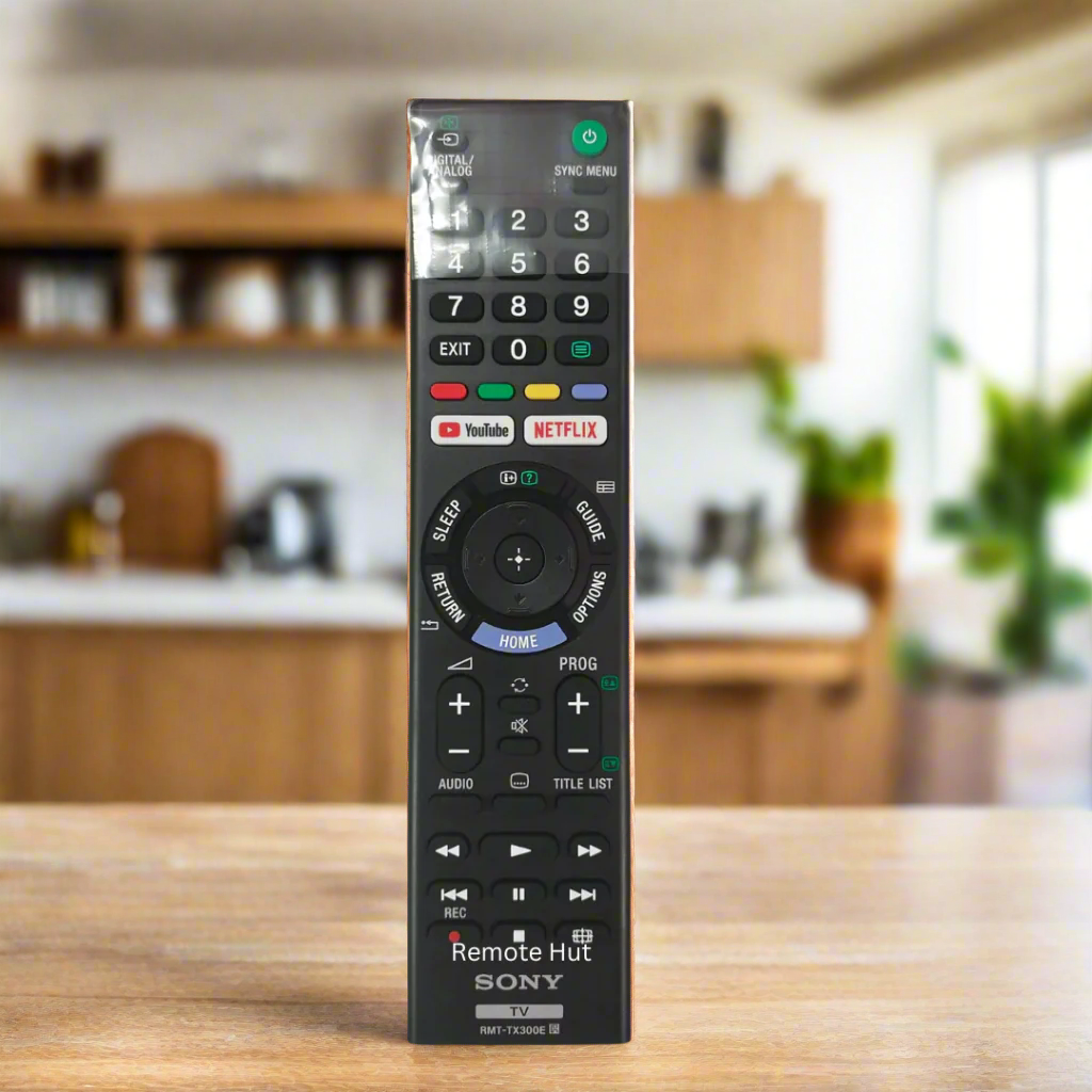 Black remote control with various buttons on a light gray background