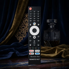 Black remote control with various buttons on a marble surface